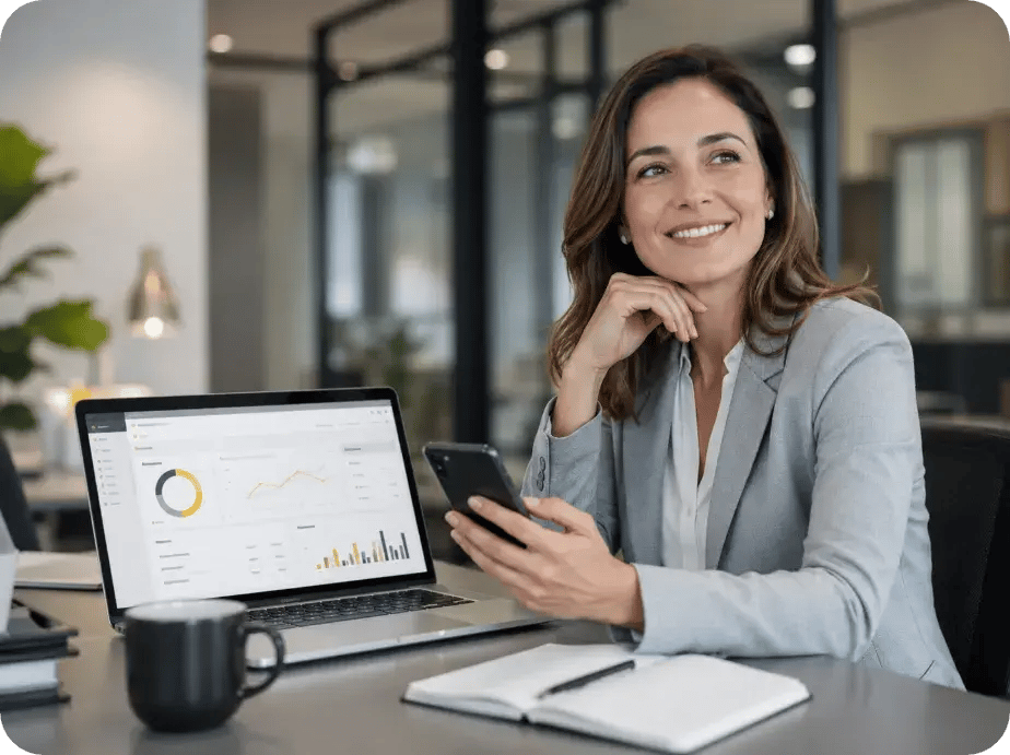 Una tesorera analizando en su laptop y smartphone cómo optimizar la liquidez empresarial y generar rendimientos en el mercado de dinero para que el capital no pierda valor.